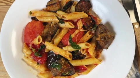 Pasta with baked eggplants, tomatoes, fresh basil and grated cheese Stock Footage 345669799