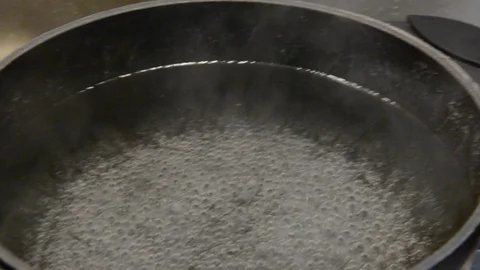 Pasta being poured into a pot of boiling water.  Stock-Footage 120572436