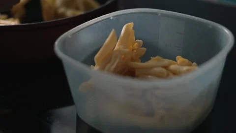 Pasta is being prepared in a kitchen as the cook uses a spoon to mix the noodles Stock Footage 338304187