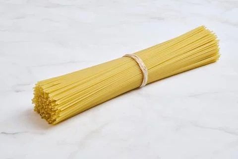 Pasta bundle on light marble surface ready for cooking a delicious meal 库存照片