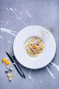 Pasta carbonara with quail egg, plate full of Italian tagliatelle with ham an Stock Photos