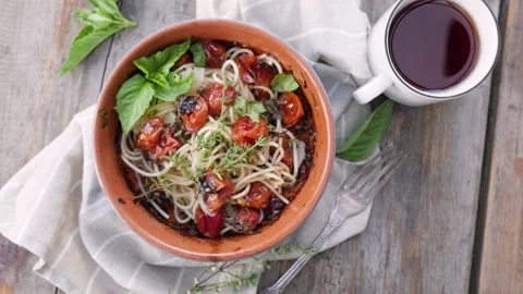 Pasta with cherry tomatoes, cheese and basil on a wooden background in a rustic Stock-Footage 148189662