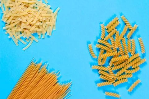 Pasta concent. Differernt types of pasta on blue background. Creative layout Stock Photos