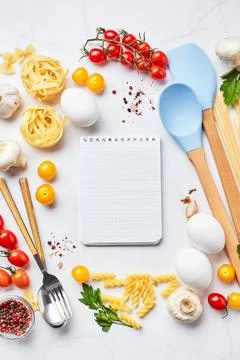 Pasta cooking background with notepad for text, tomatoes, herbs, mushrooms, eggs Stock Photos