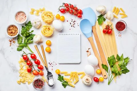 Pasta cooking background with notepad for text, tomatoes, herbs, mushrooms, eggs Stock Photos