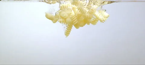 Pasta falling in clear water. Mesmerizing fluid art Stock Footage 323437849