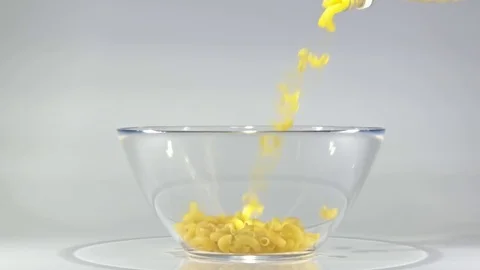 Pasta falling into the glass bowl. Stock Footage