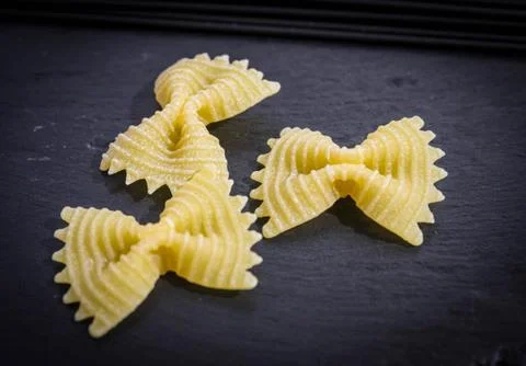 Pasta farfalla on a black basalt background. Three bows Stock Photos