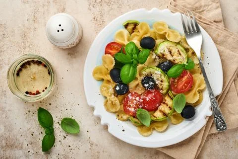 Pasta fiocchi salad with vegetables grilled zucchini, cherry tomato, olives,  Stock Photos