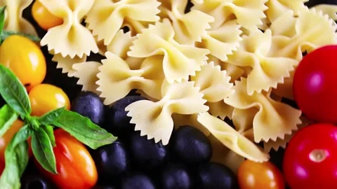 Pasta ingredients, raw pasta, cherry tomatoes, olives and basil leaves Stock Footage 151884587
