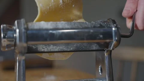 A pasta machine is shown with a piece of pasta coming out of it Stock Footage 305983390