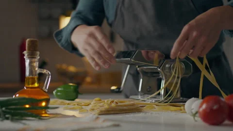 Pasta, A man in the kitchen at home Cooks spaghetti by hand on Italian equip Stock Footage 245806648