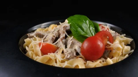 Pasta with meat, served with parmesan cheese, cherry tomatoes and basil leaf Stock Footage 80709156
