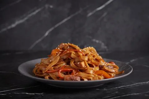Pasta with meat, spaghetti, noodles, plate on a dark background, asian cuisine Stock Photos