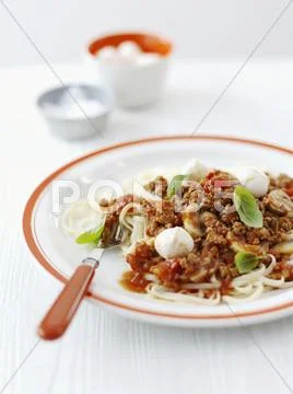 Pasta with a minced meat sauce, mozzarella and basil Stock Photos