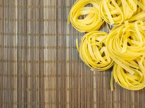 Pasta nests on a wicker background. Type of noodle. Culinary background. Cook Stock Photos