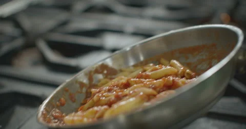 Pasta in pan are mixed in slow motion. Video 4K Stock Footage 103334141