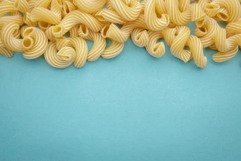 Pasta penne rigate on blue background Stock Photos