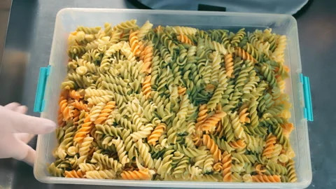 Pasta in a plastic container for delivery. Mixing and packing cooked hot pasta Stock Footage 170555229