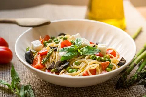 Pasta primavera spaghetti close up with cherry tomatoes, black olives, feta Fotos Stock