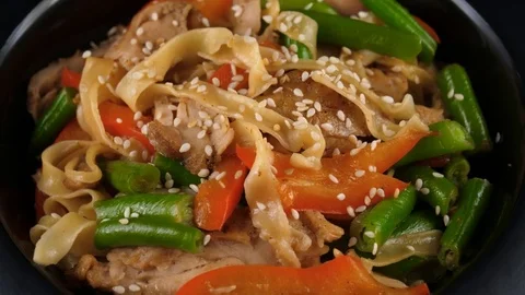 Pasta with roasted chicken fillet, vegetables, served tomatoes and sesame seeds Stock Footage 80797487