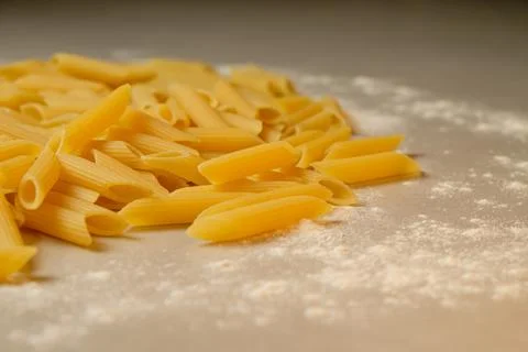 Pasta scattered on a kitchen surface with a dusting of flour Stock Photos