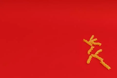 Pasta scattered on a red background Stock Photos