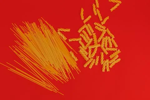 Pasta scattered on a red background Stock Photos