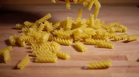 Pasta shapes fall on kitchen table, slow motion Stock Footage 55760547