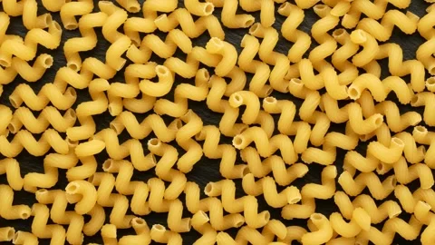 Pasta in a spiral shape on a black background. Video stock 138344372
