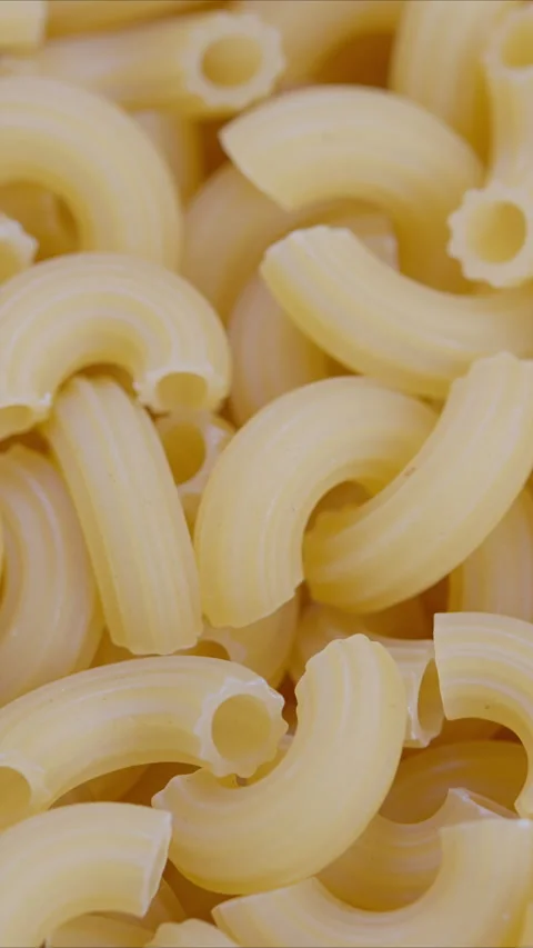 Pasta surface patterns, Repetitive macaroni curves in warm hues emphasizing surf Stock Footage 325691526