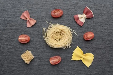 Pasta on the table, decorated with cherry tomatoes. Pasta of different shapes. Foto stock
