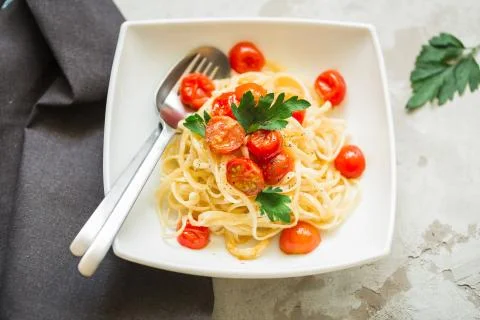 Pasta with tomatoes cherry on the kitchen table, top view Stock Photos