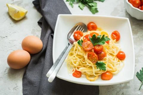 Pasta with tomatoes cherry on the kitchen table, top view Stock Photos