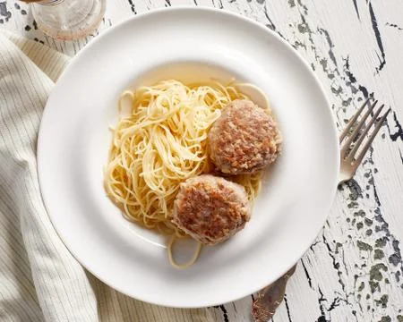 Pasta with two cutlets on rustic white table Stock Photos