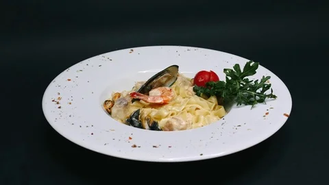 Pasta on a white plate with seafoon on background in 4k resolution Video stock 112062541
