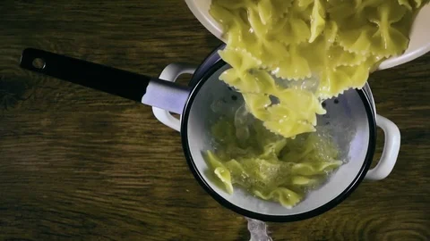 The paste pours out of the pan into a colander. Slow motion, top view Stock Footage 74587929