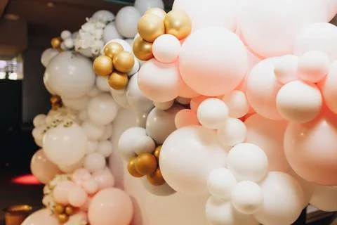 Pastel balloons float in soft pink, white, and gold hues Foto stock