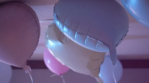 Pastel balloons floating against ceiling in party atmosphere Stock Footage 346350396