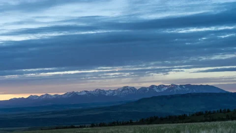 Pastel clouds moving over distant mountain range sunset Stock-Footage 167109506