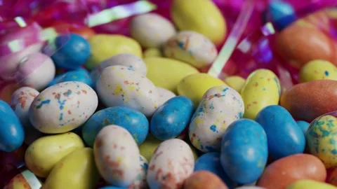 Pastel colored candy eggs rotating with pink ribbon streamers Stock Footage 327829357