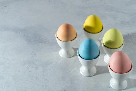 Pastel colored easter egg assortment in white cups Stock Photos