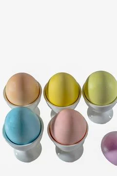 Pastel colored easter egg assortment in white cups Stock Photos