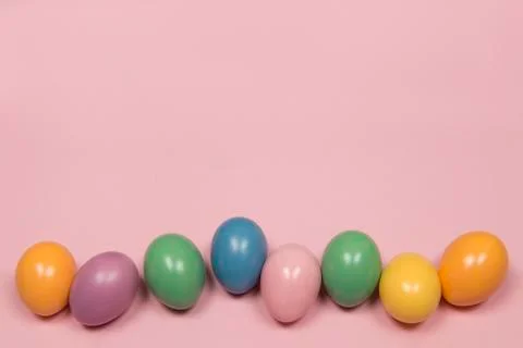 Pastel colored easter eggs on a pink background with copy space Stock Photos