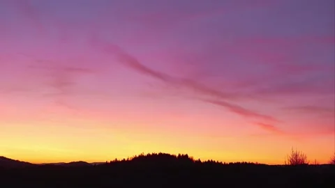 Pastel colored sky over forest silhouette, slow motion clouds. 4K Stock Footage 174169338