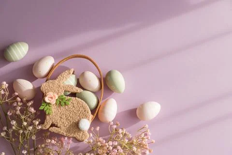 Pastel Easter Bunny Basket with Eggs and Flowers on Lavender Background Stock Photos