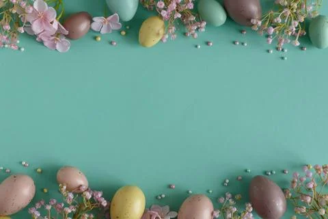 Pastel Easter Eggs and Flowers on Teal Background. Festive Spring Flatlay Stock Photos