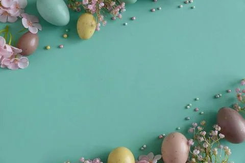 Pastel Easter Eggs and Flowers on Teal Background. Festive Spring Flatlay Stock Photos
