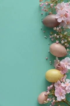 Pastel Easter Eggs and Flowers on Teal Background. Festive Spring Flatlay Stock Photos