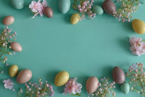 Pastel Easter Eggs and Flowers on Teal Background. Festive Spring Flatlay Stock Photos